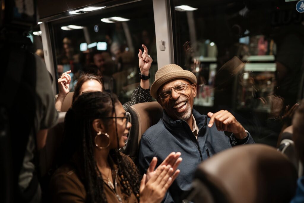 Two guests laughing while being taken by their coach driver around the balkans