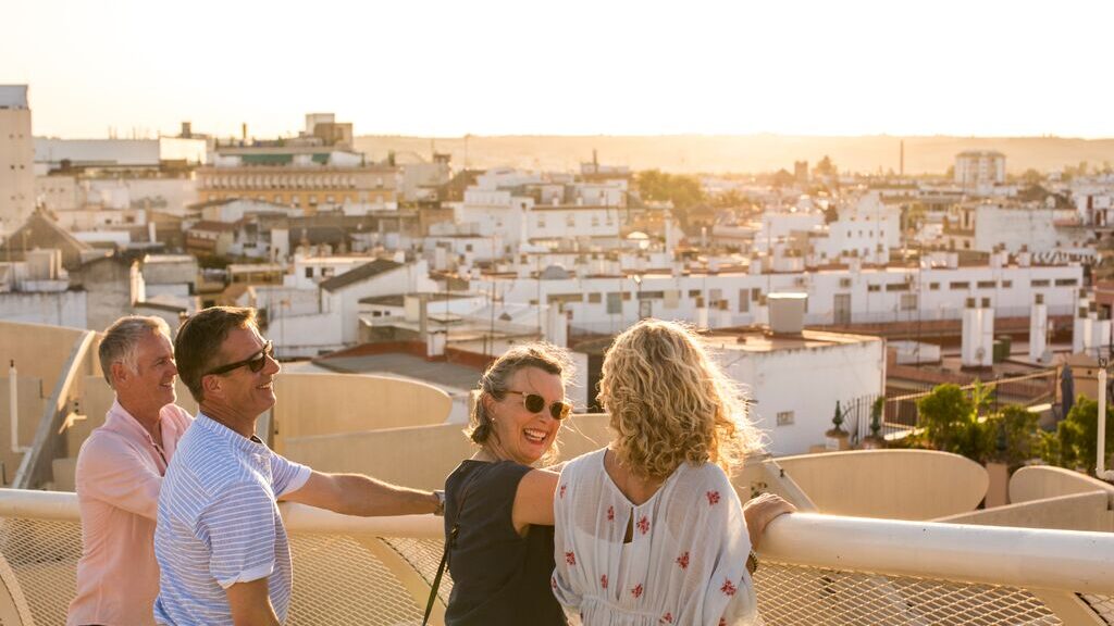 Four guests exploring in Seville, stood looking over the buildings and landscapes. Two men, two women.