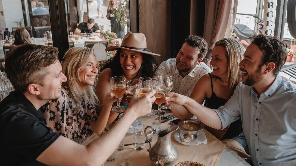 Group of Trafalgar guests clinking glasses around a table