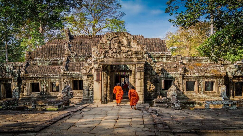 Two monks walking in front of a temple, fulfilling their travel bucket list.