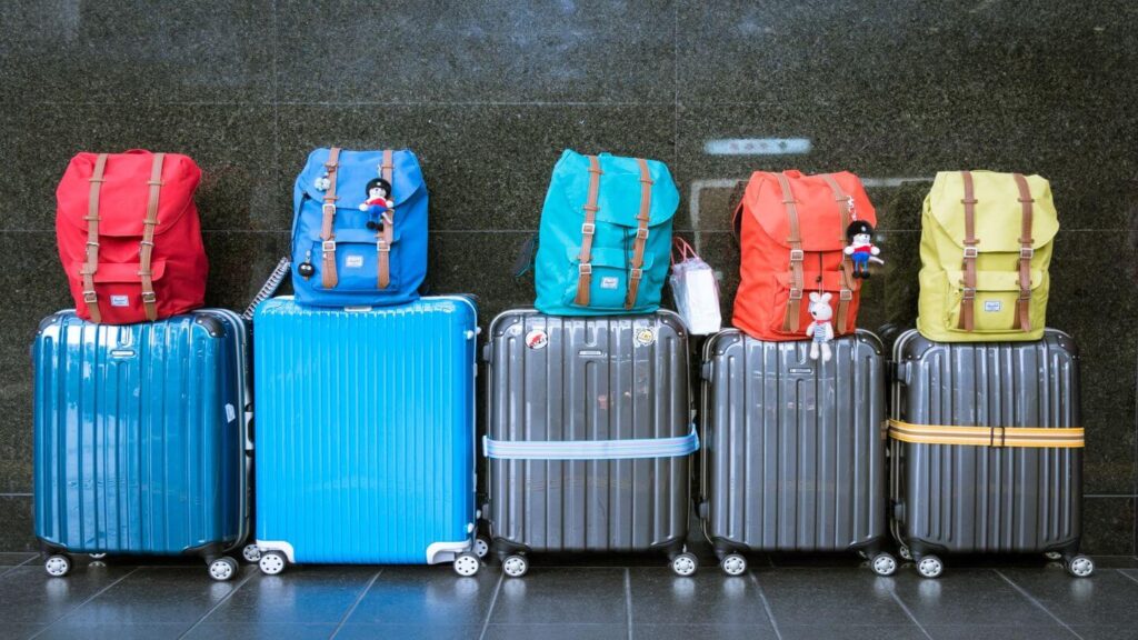 Colorful suitcases are lined up against a wall, perfect for frequent flyers looking for travel inspiration.