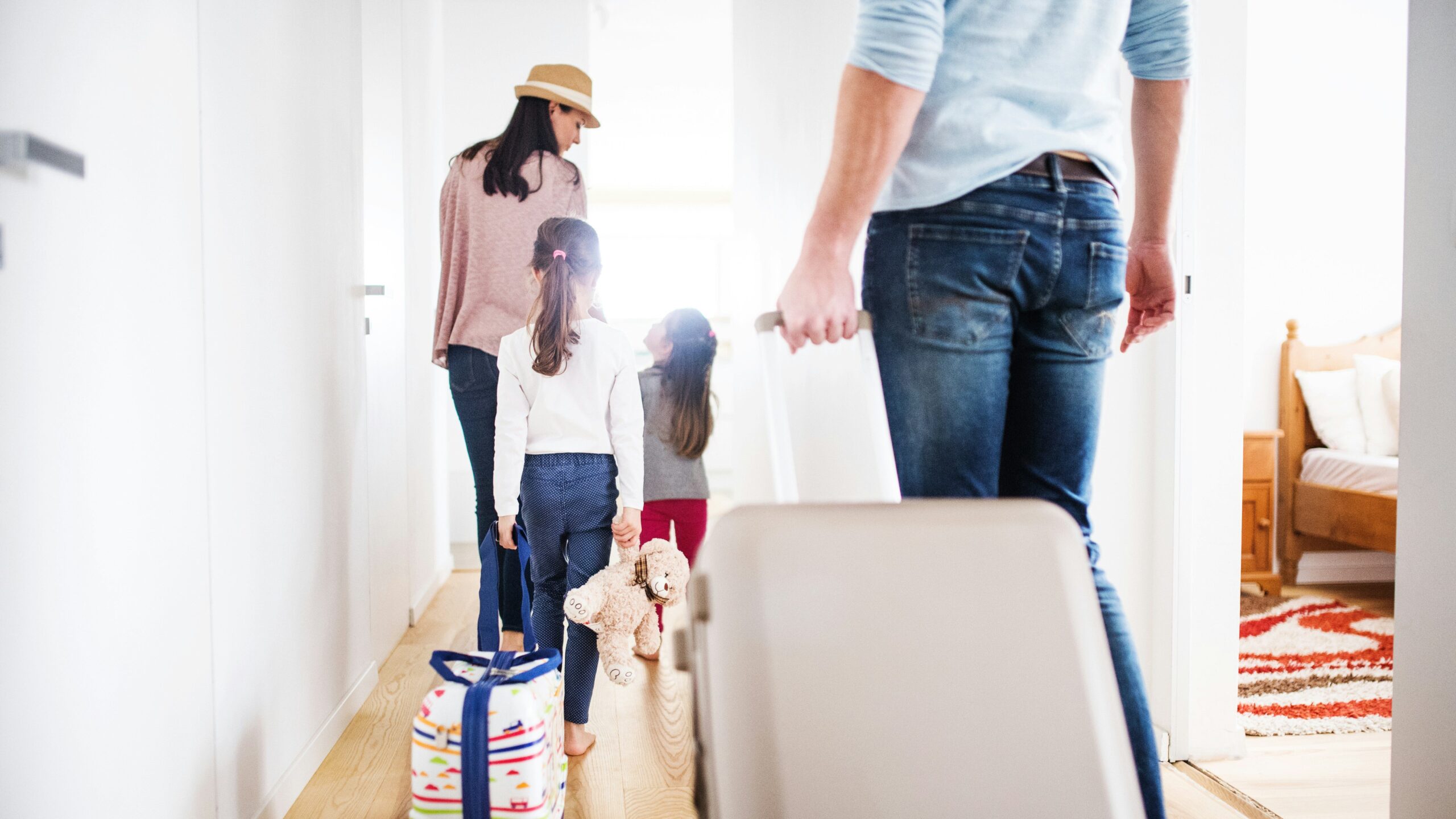family leaving the house with suitcases