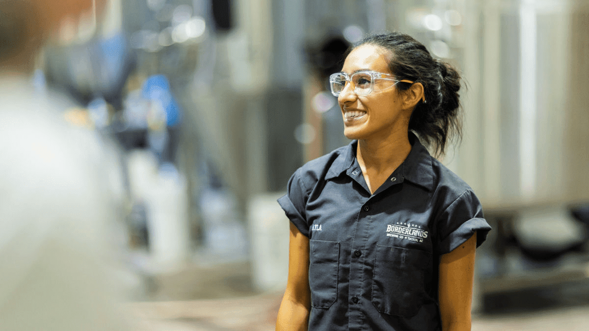 A woman at the Borderlands brewing company is smiling