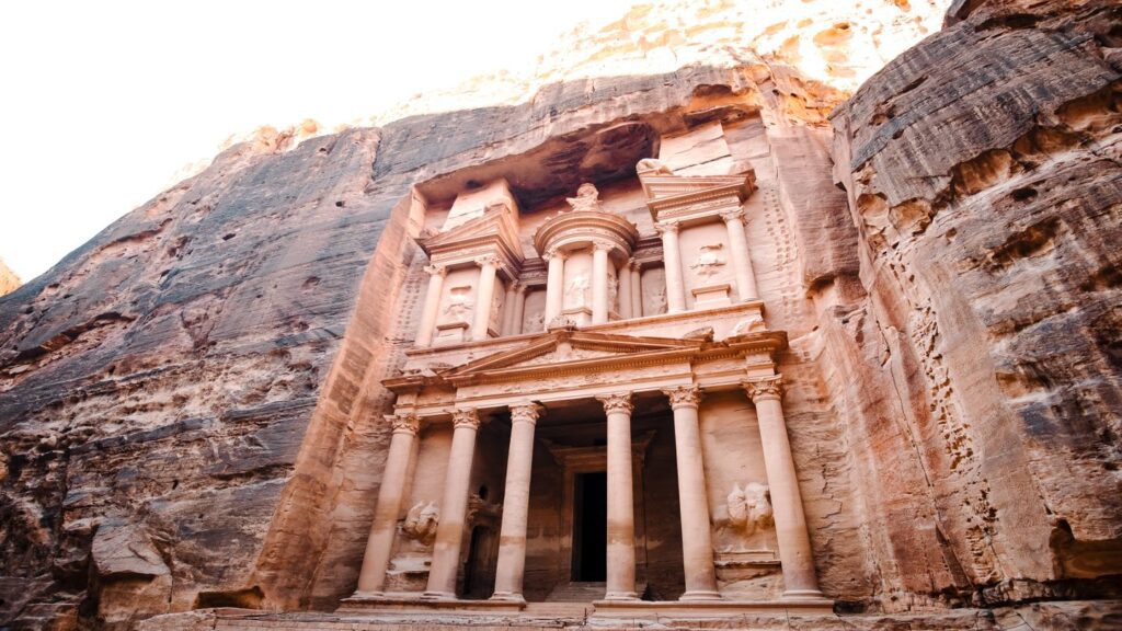 Escape to the ancient rock-cut facade of Al Khazneh (the Treasury) at Petra, Jordan, bathed in soft sunlight this next half term.