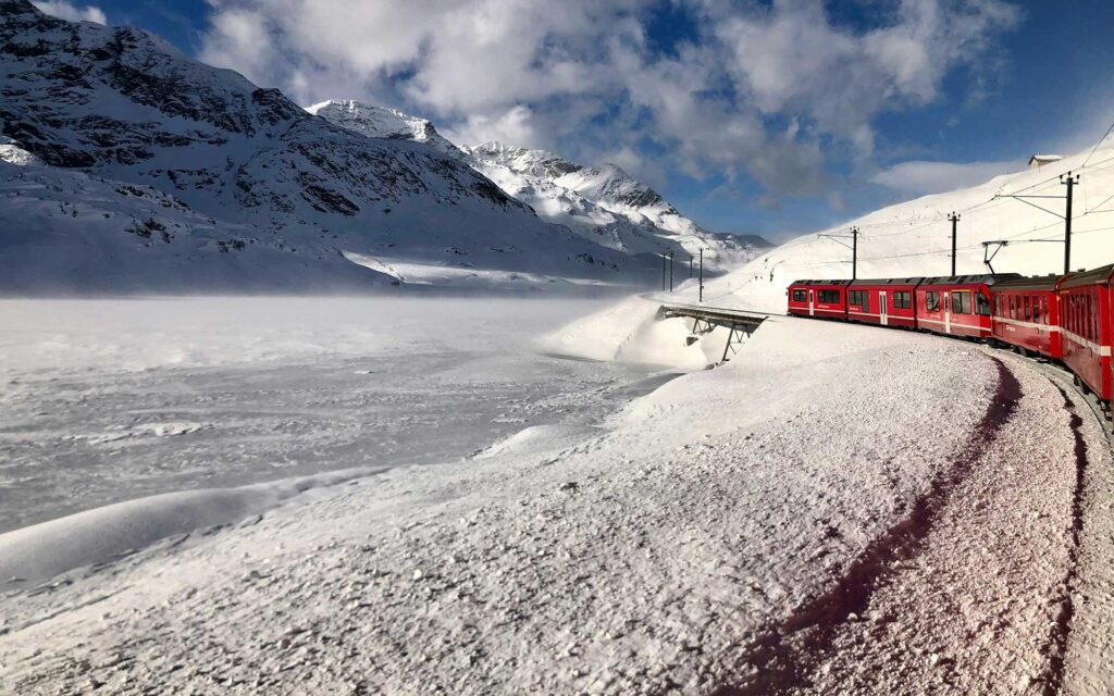 A red train traveling through a snowy landscape