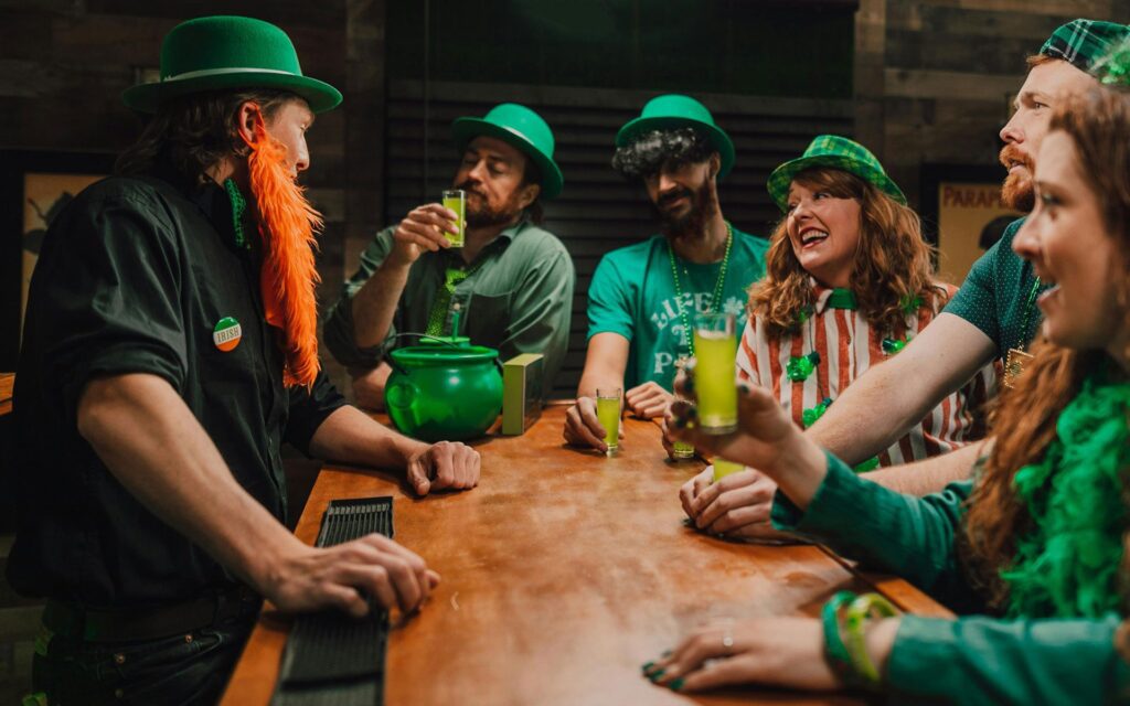 People dressed in green St Patrick's Day themed outfits drinking at a bar