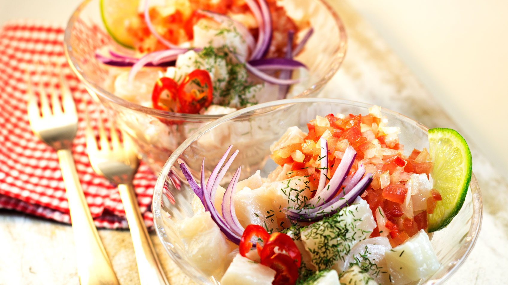 Two bowls filled with fish prepared in Peruvian Cuisine.