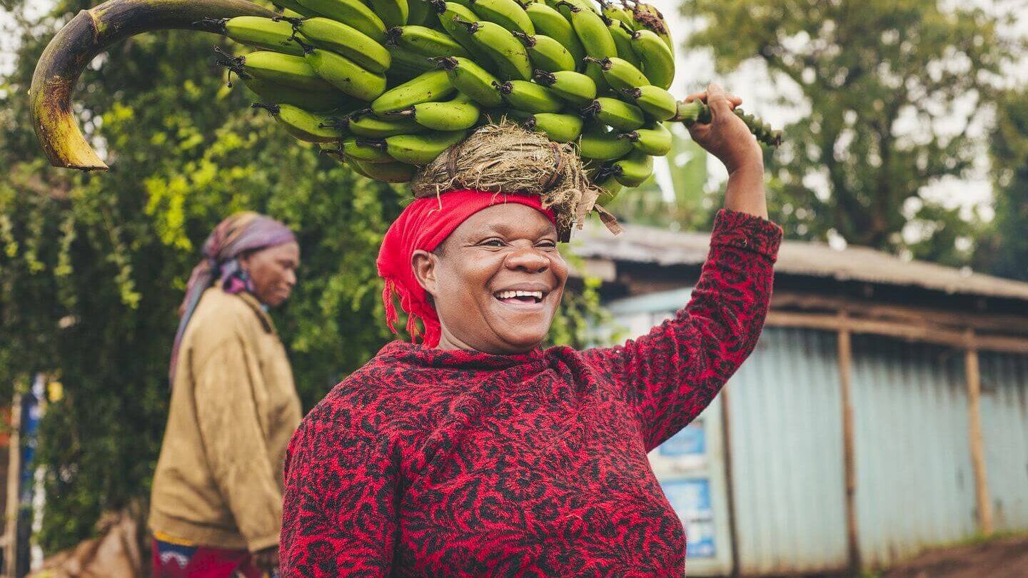 Tanzanian woman carrying bunch of bananas on her head Tanzanian culture