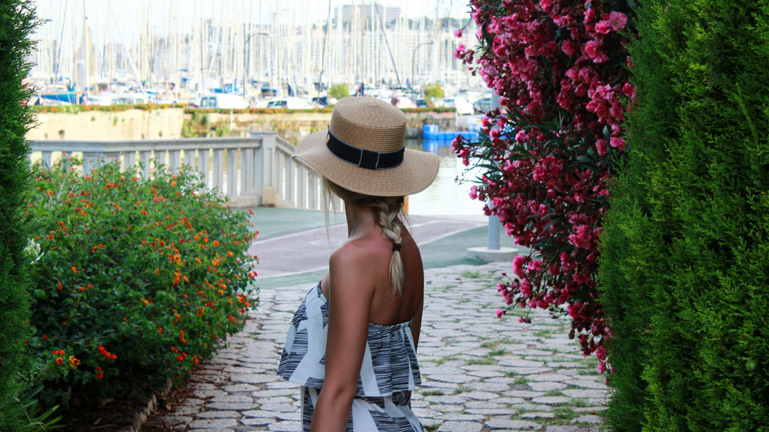 woman on a pathway in a sun hat, a europe packing essential