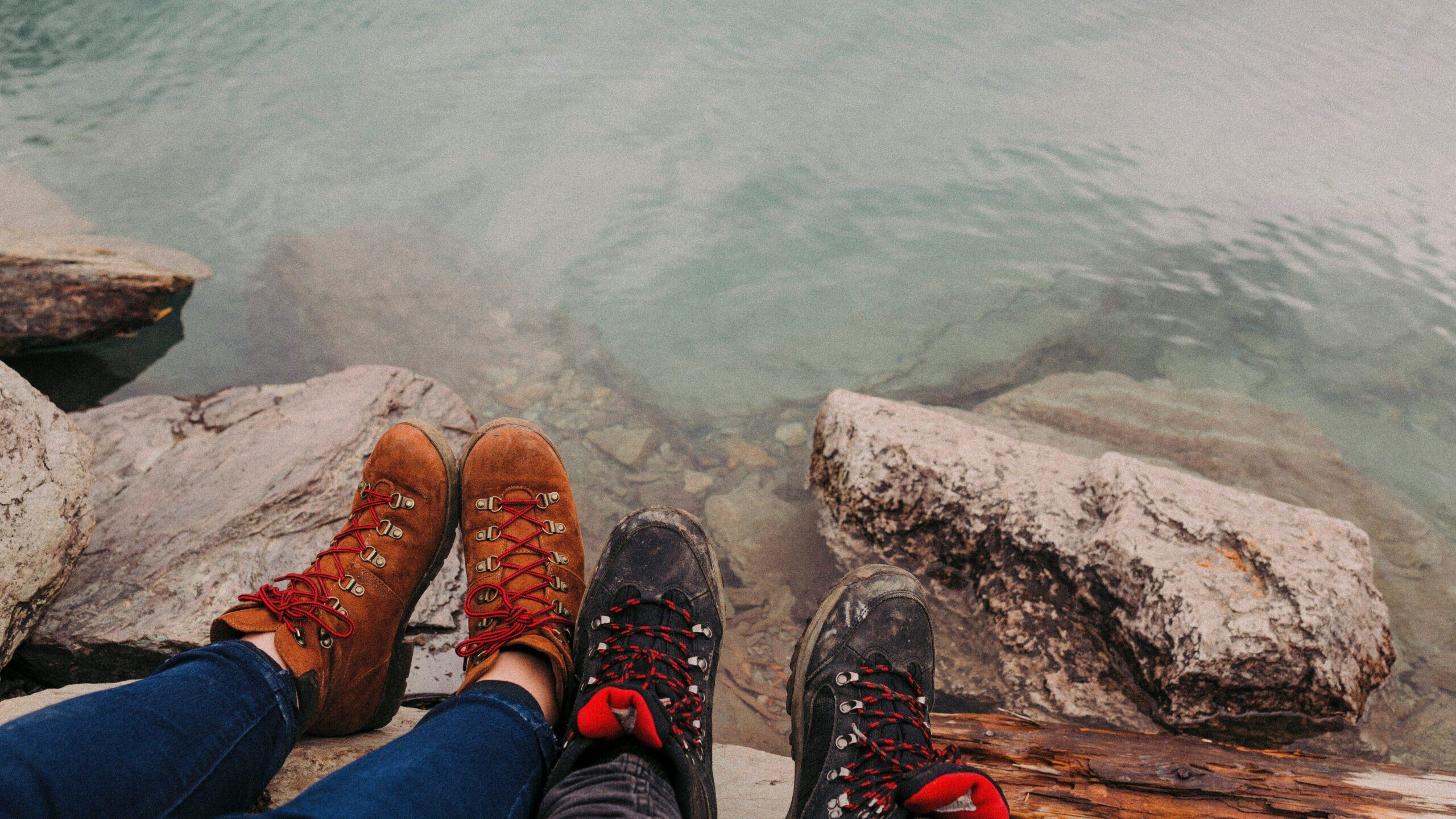 view of two sets of walking boots near a lake