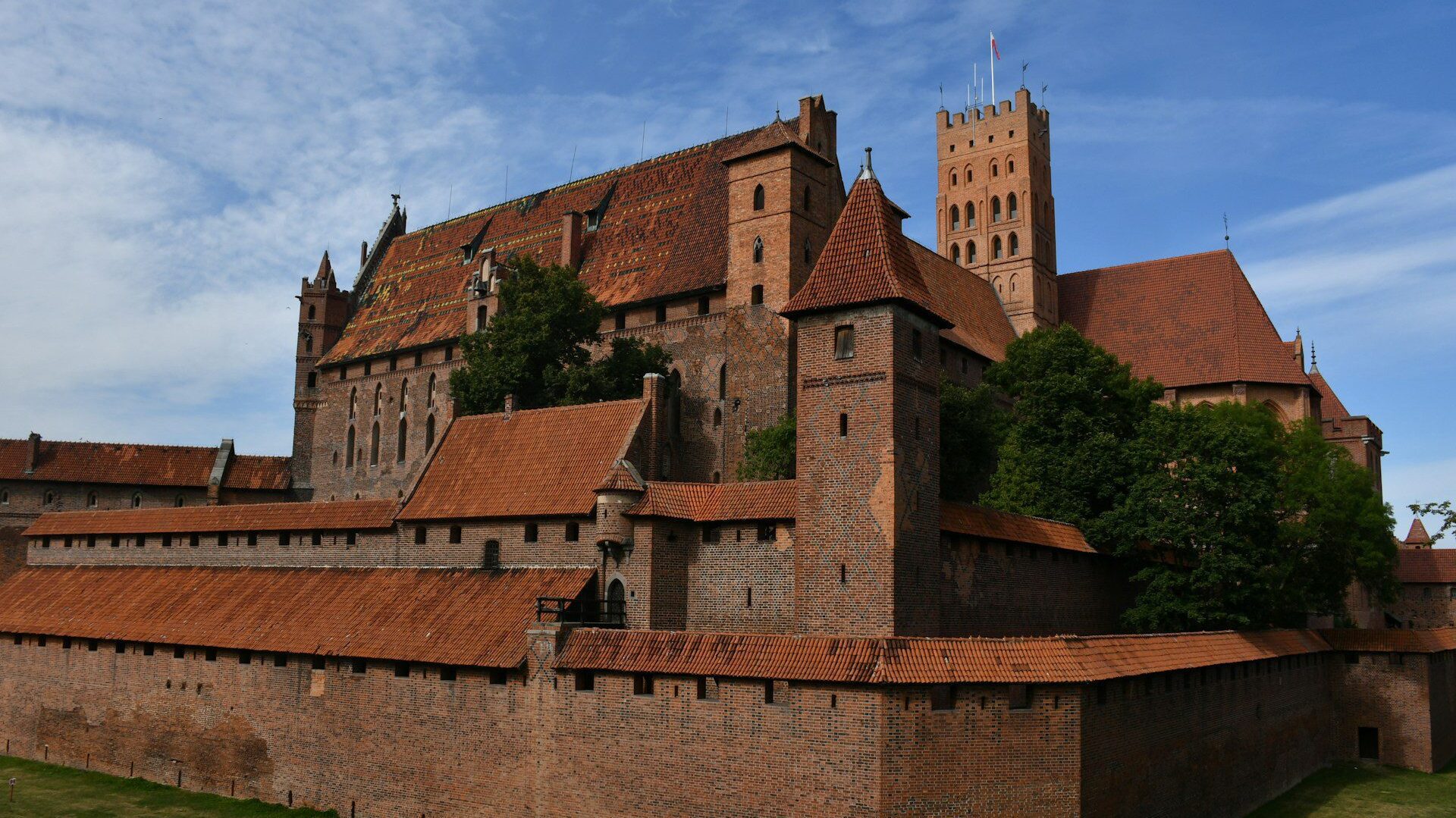 Exterior of a large red brick castle against a blue sky