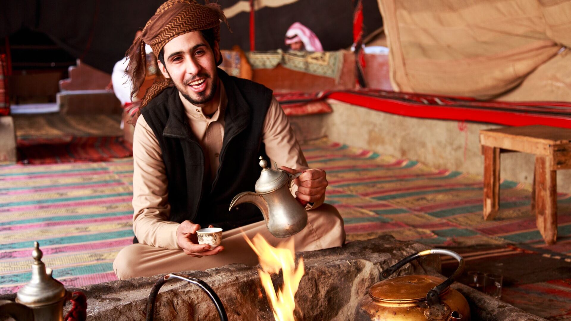 bedouin man making coffee in a traditional tent