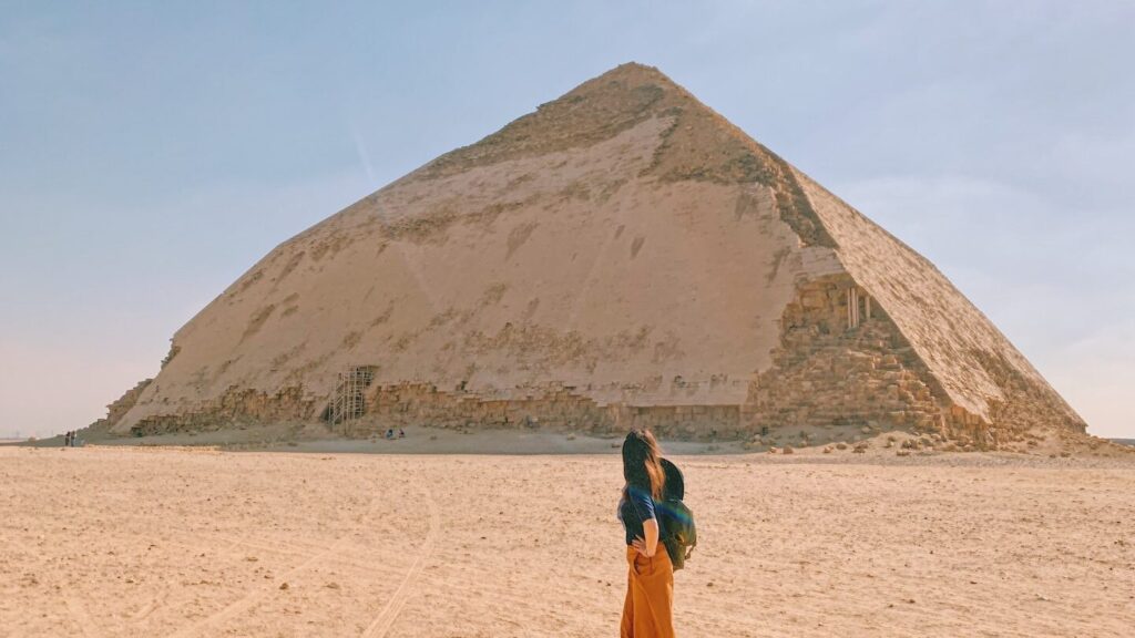 A person preparing for their trip to Egypt, observing the bent pyramid in the Egyptian desert.