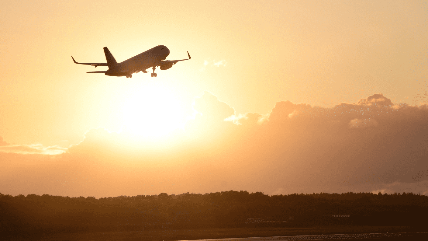 Silhouette of a plane flying into the sunset