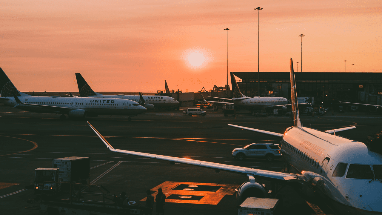 Planes waiting at an airport during sunset