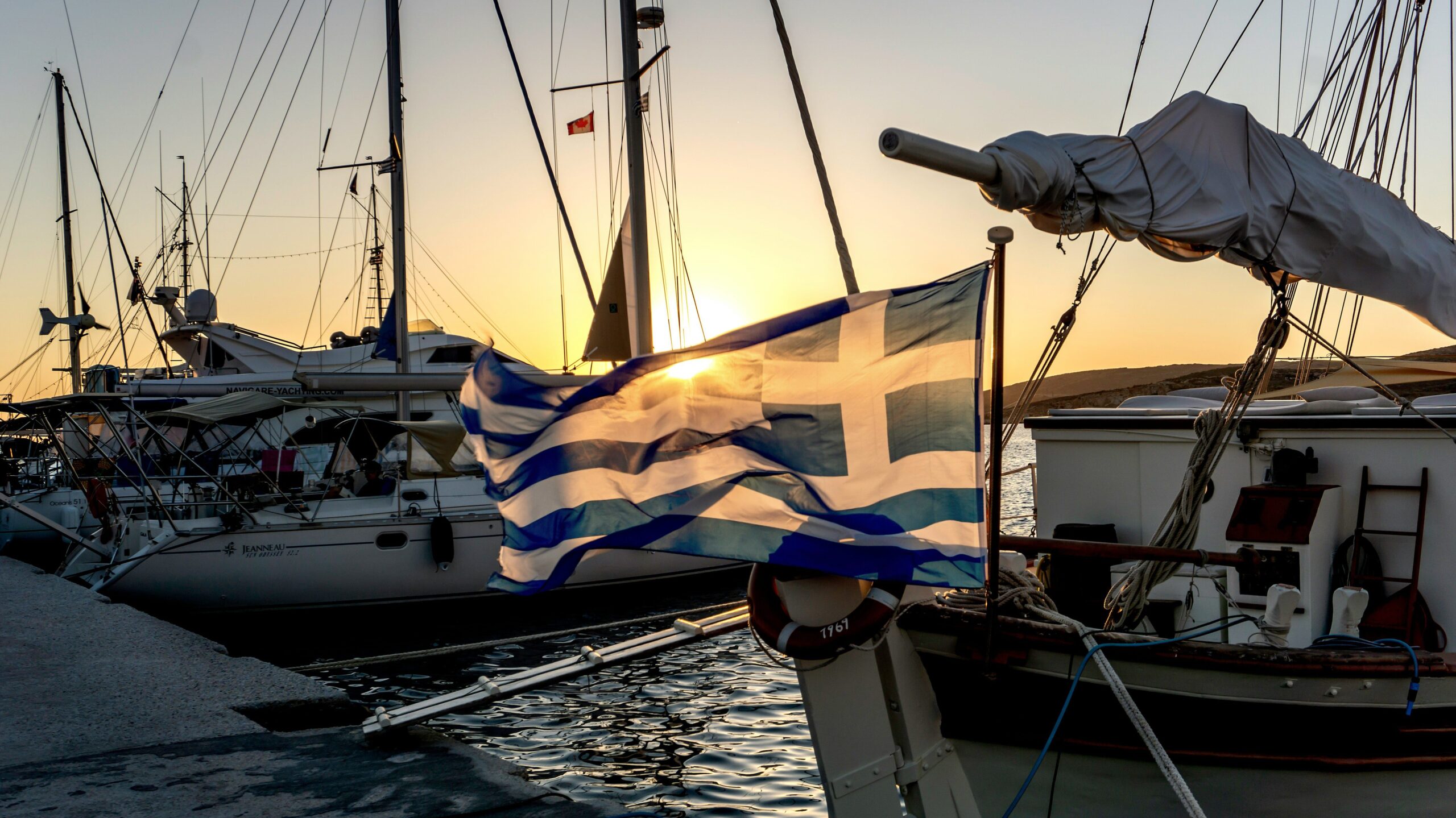 greek flag blowing on the back of a boat
