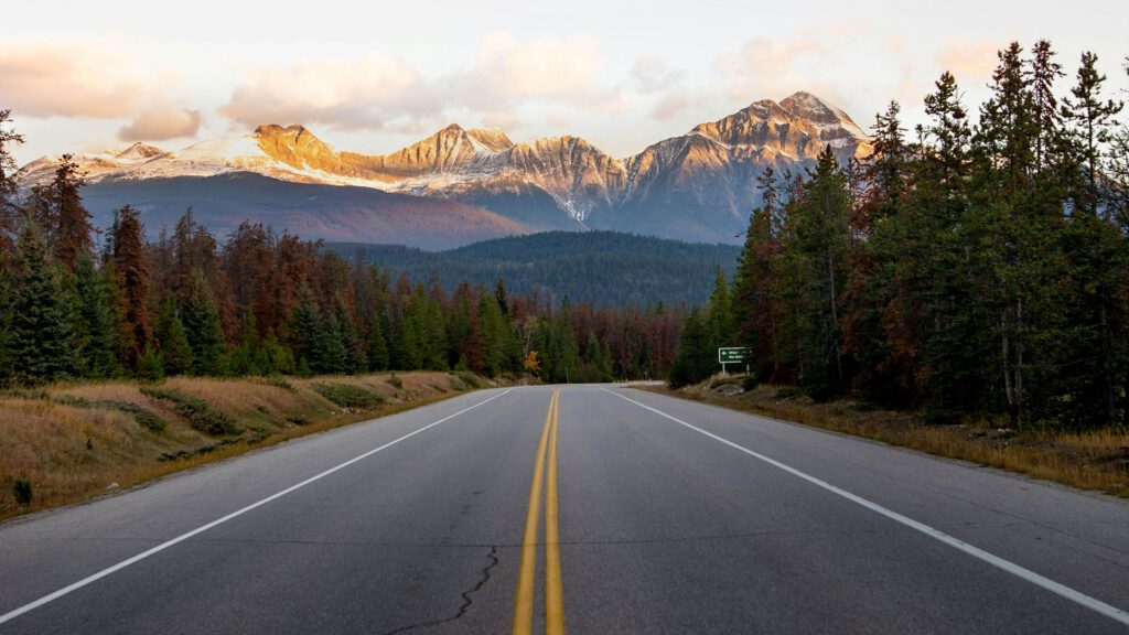 Backcountry road heading round a corner with mountains in the distance