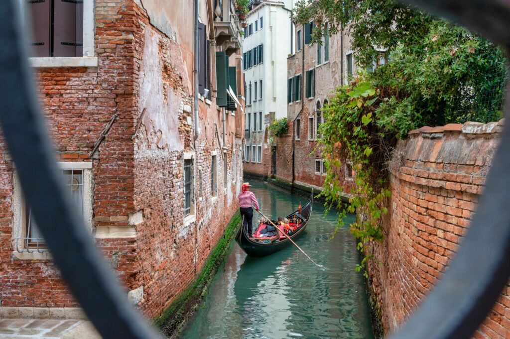 Gondolier maneuvering down a narrow canal in Venice