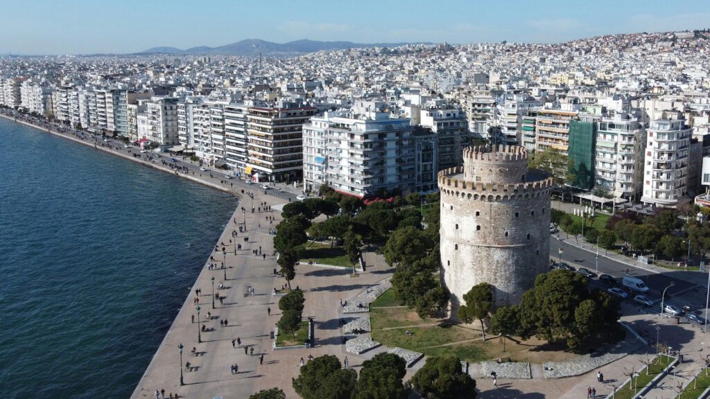 White stone tower near the edge of a coastal city in Greece