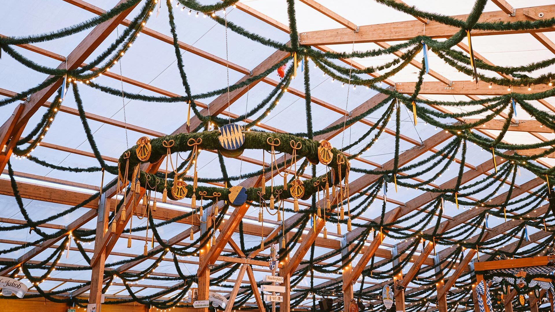 Decorative wreath hanging from the rafters of a beer hall tent at Oktoberfest 