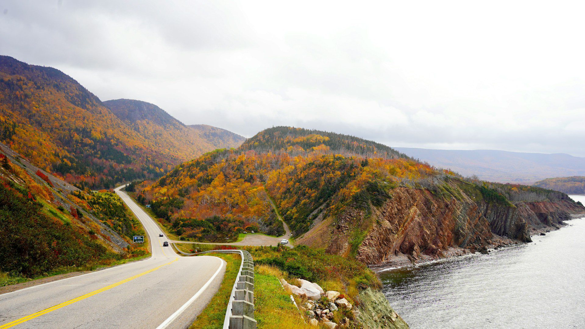 Road running through an autumnal landscape, alongside the coastline in Nova Scotia