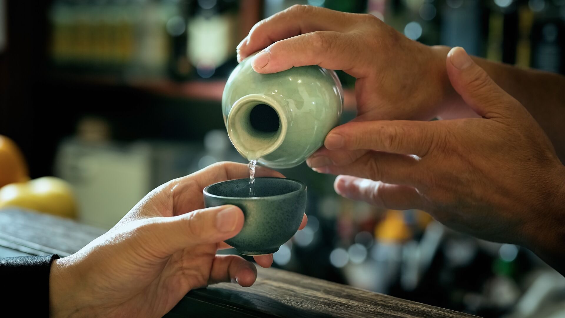 bartender pouring sake into a glass
