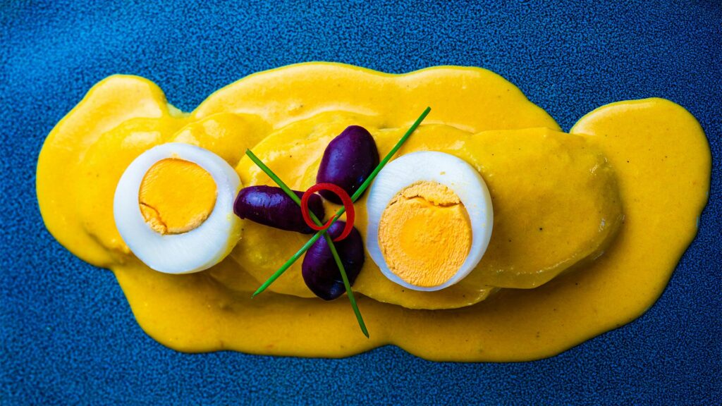 Boiled yellow potatoes covered in vibrant Peruvian Huancaína cheese sauce.