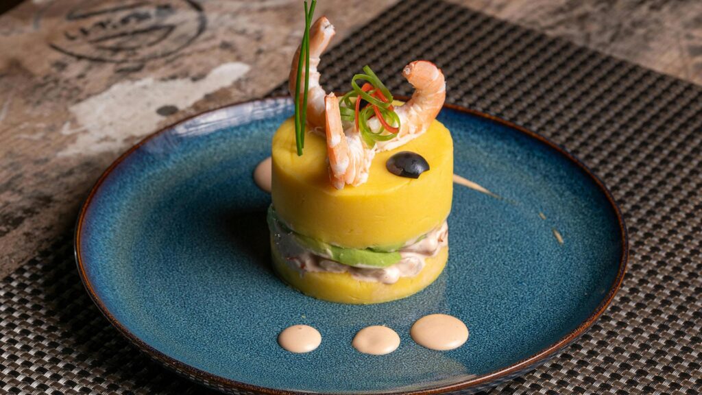 Causa Limeña: Cold, layered Peruvian Causa potato casserole filled with avocado and tuna/chicken.