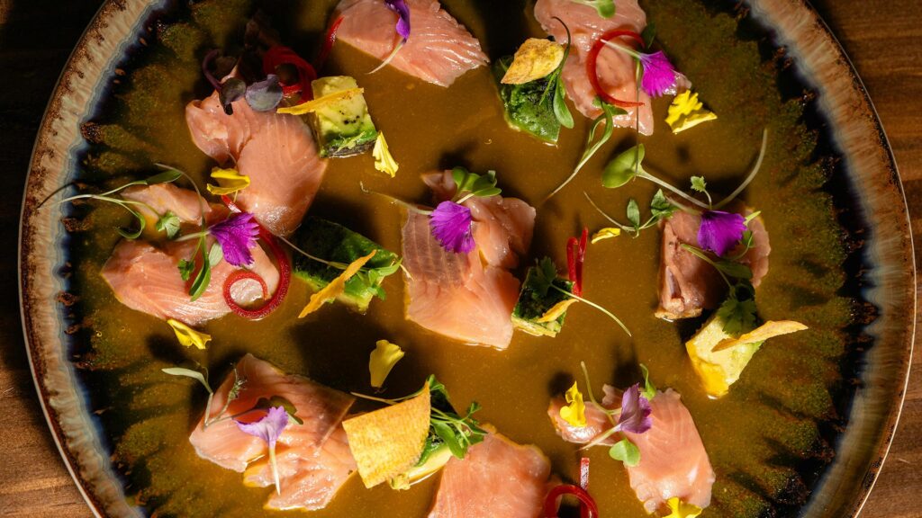 Thin slices of raw fish doused in creamy Peruvian ají sauce (Tiradito style).
