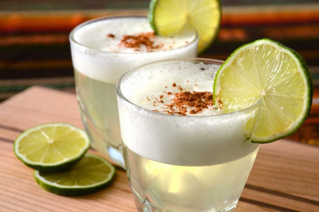 Two glasses of Pisco Sour, a Mexican iced tea with cinnamon and lime.
