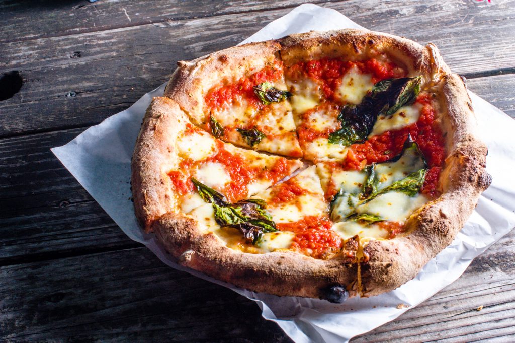 A neopolitain style Margherita pizza on a sheet of white paper