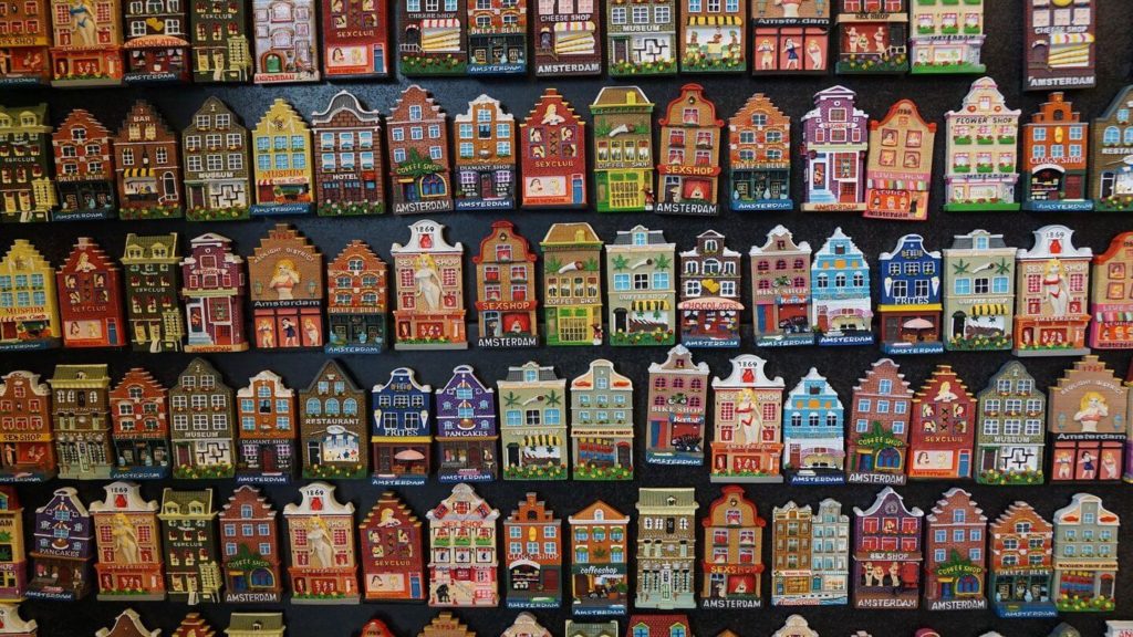 A display of wooden houses, part of a travel souvenir collection, hung on a wall.