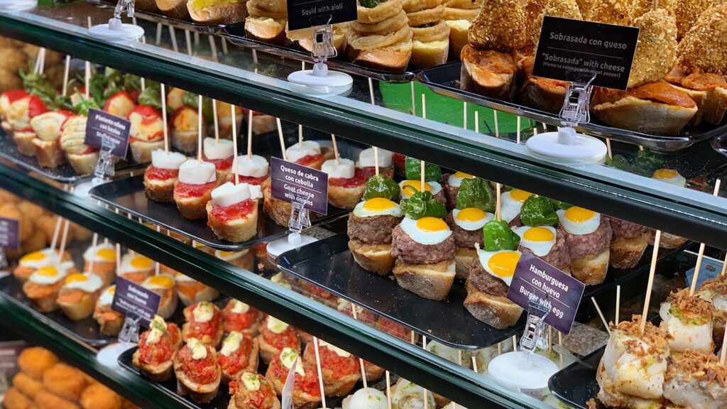 A glass display case filled with pre-made tapas or pintxos in Spain