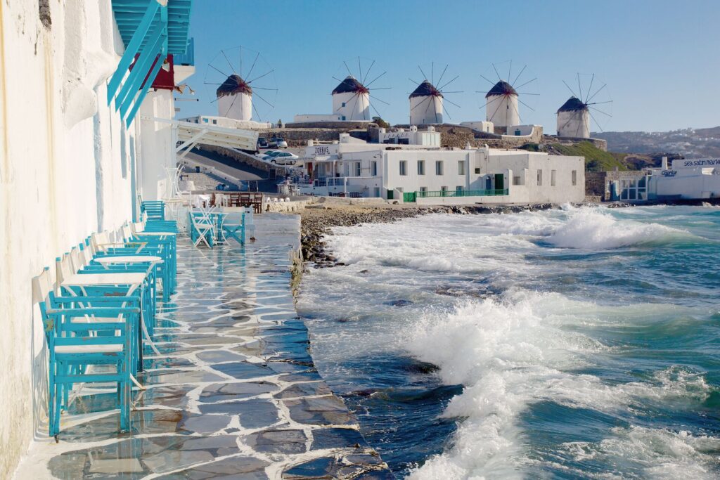waterfront cafe and view of windmills in mykonos