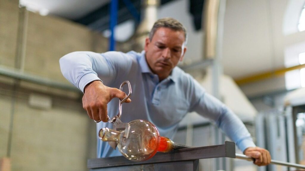 A man working on a piece of blown glass