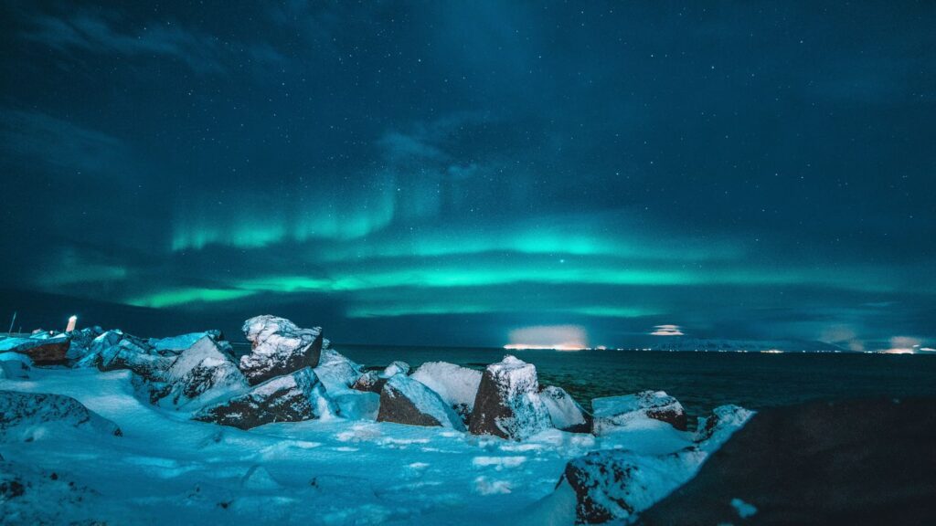 Icy landscape underneath a sky streaked with northern lights