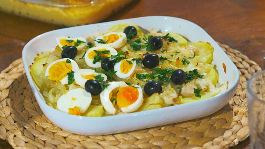 a white baking dish of bacalao, eggs and olives