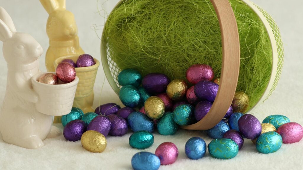 Colorful foil-wrapped easter eggs and porcelain bunnies