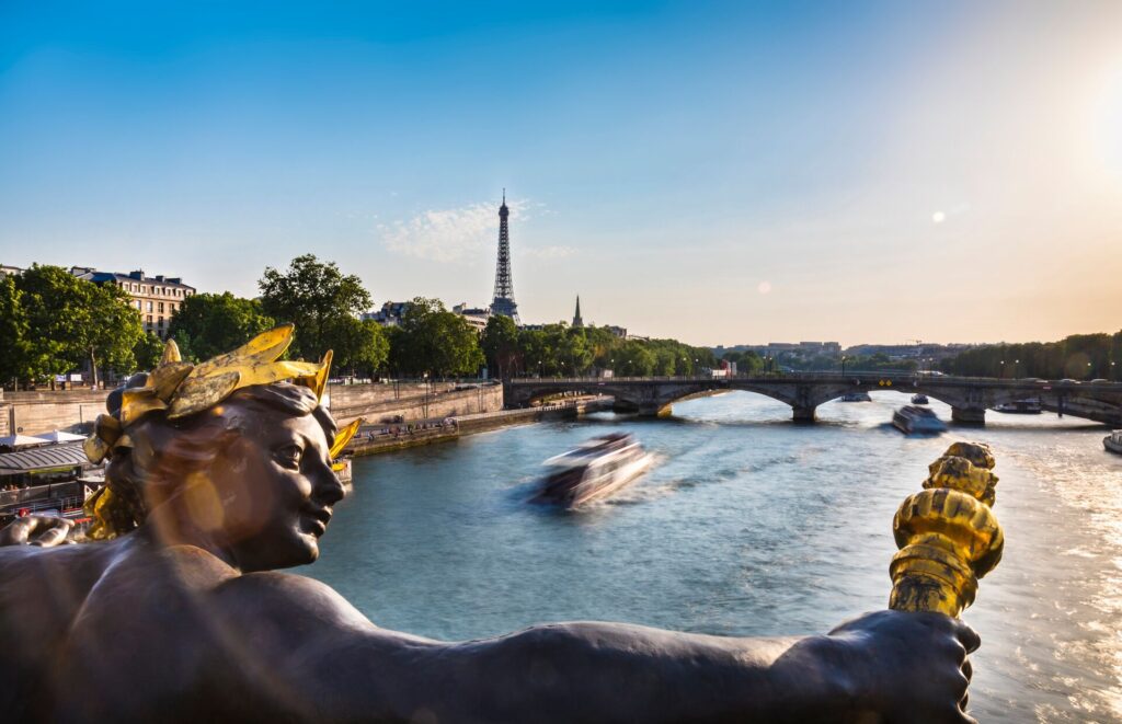 Close up of a statue on a bridge overlooking the Seine in paris with the eiffel tower in the background