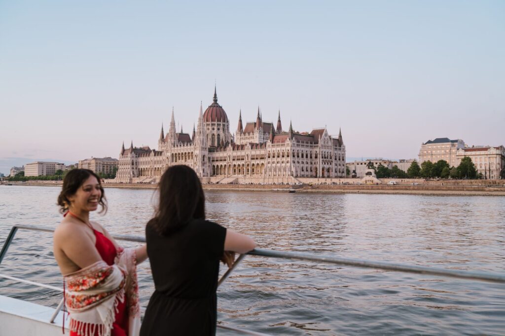 Two women on a boat cruising along the Danube River n front of Budapest's Parliament House