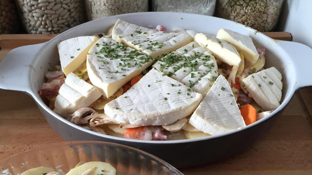 A baking dish filled with Tartiflette ready to go into the oven