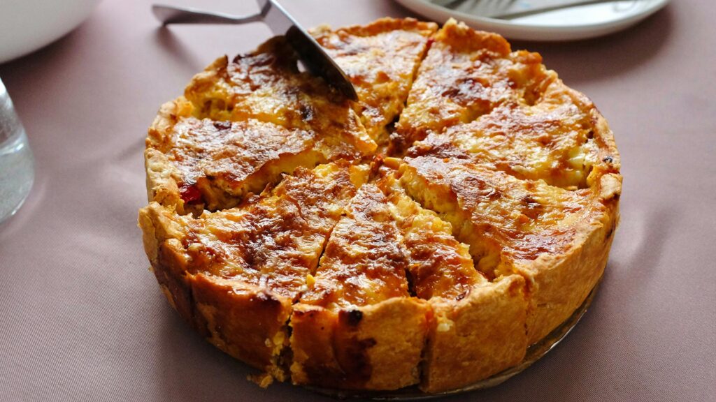 A whole sliced quiche lorraine waiting to be served