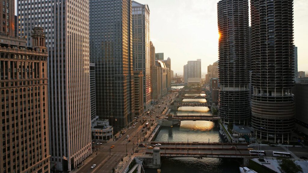A view of the Chicago River with buildings lining either side at sunset