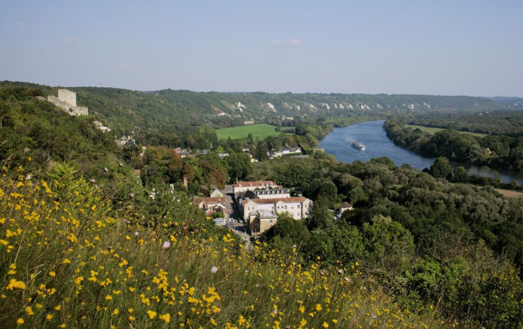 Landscape view of the river curiving to the right with the 18th-century Château de La Roche-Guyon on the left