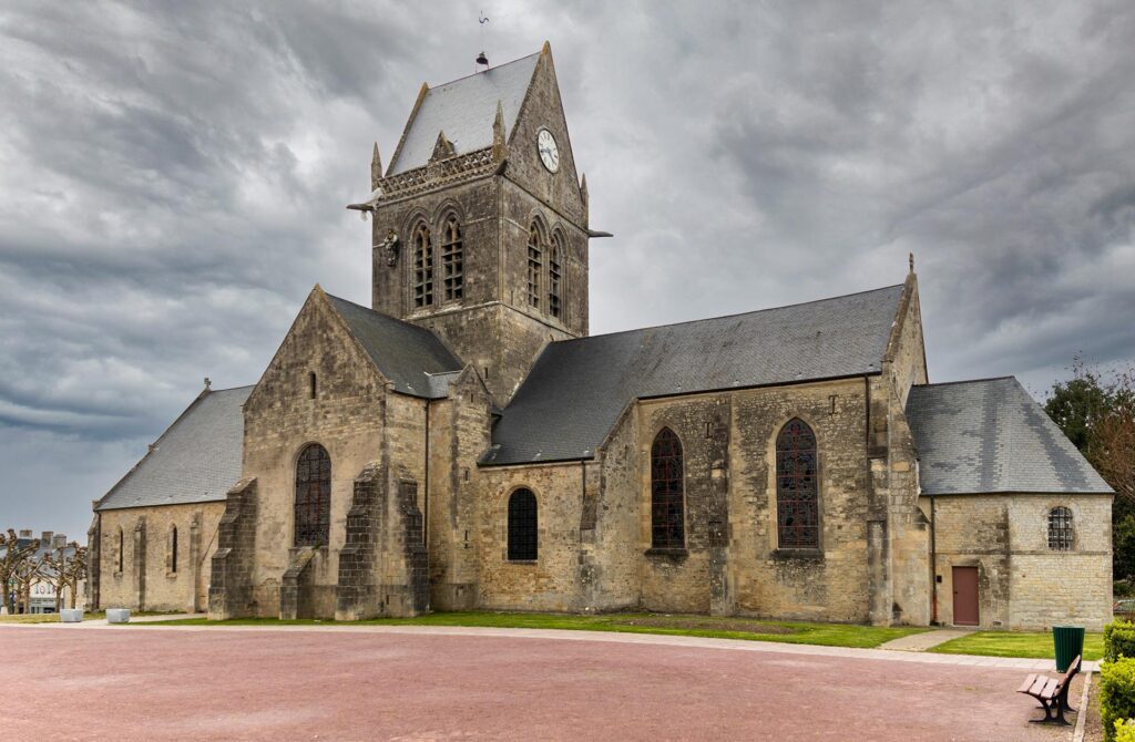 The church steeple in Sainte-Mère-Église with a tribute to the paratrooper