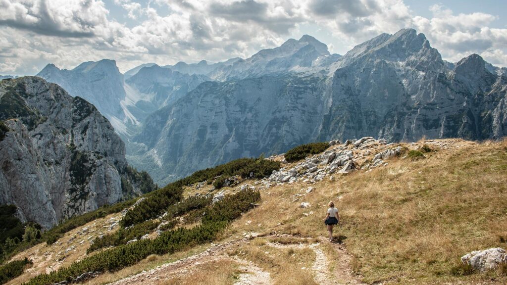 Woman hiking on a trail in Triglav National Park, Slovenia with mountains in the background