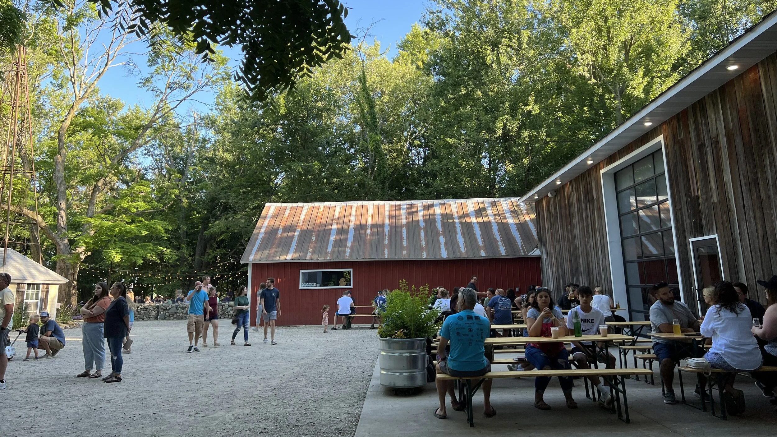 People sitting around picnic tables outside cidery