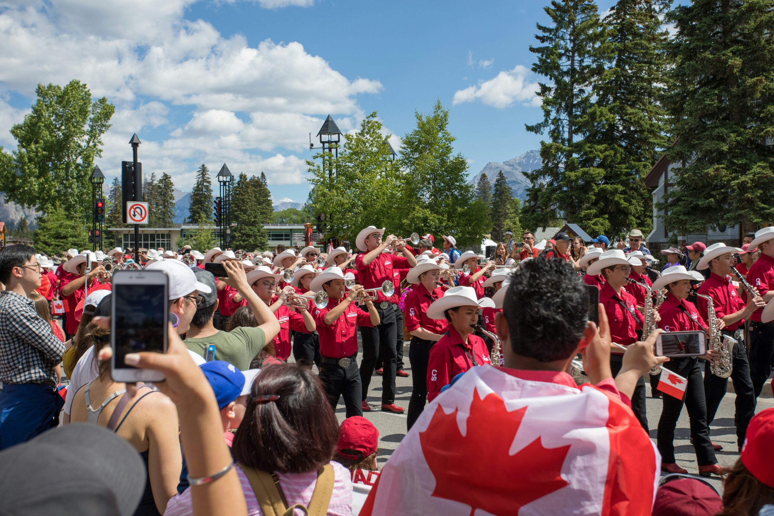 Marching band parade watched by Canadian spectators draped in Canada flags
