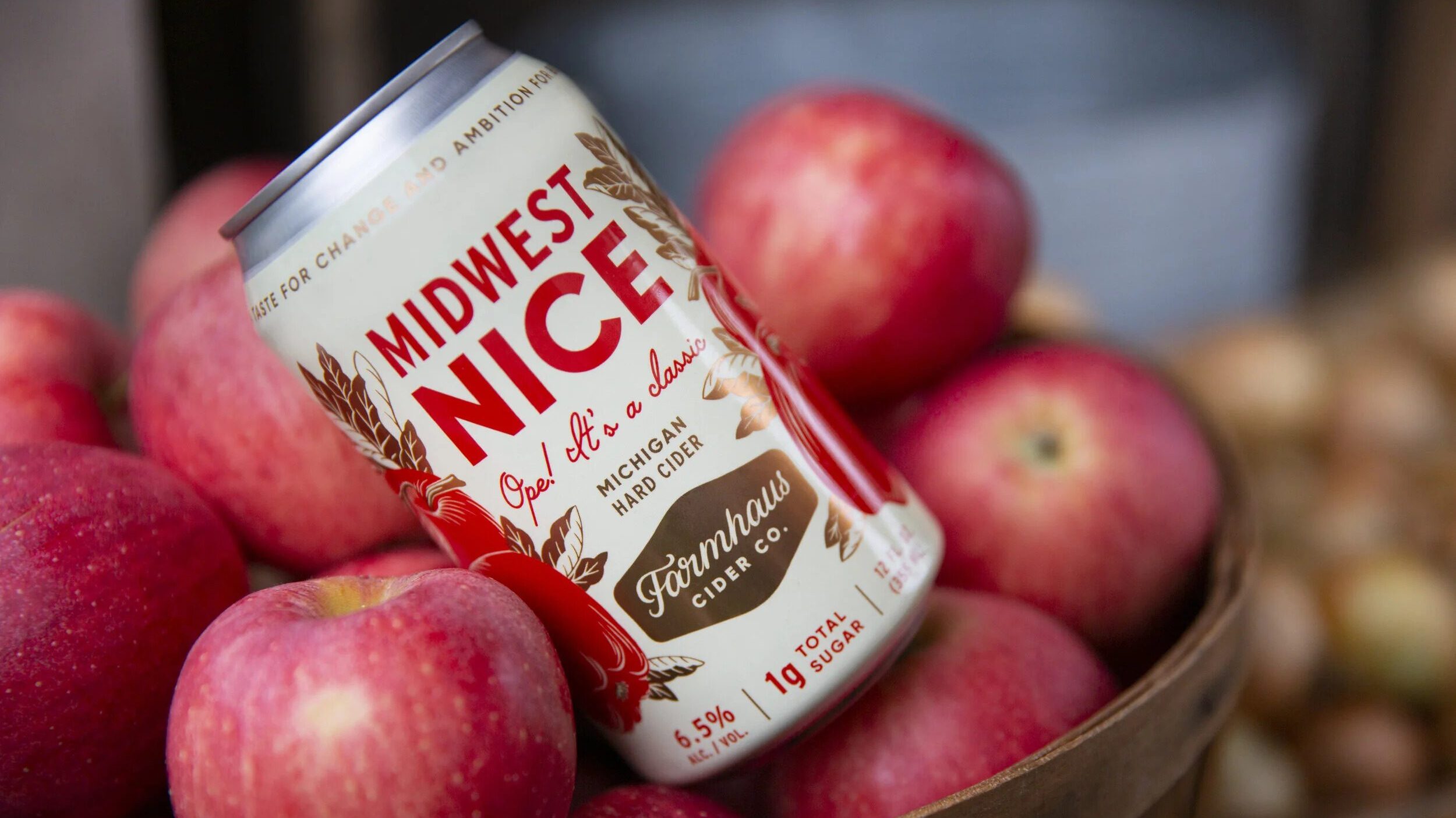 Can of cider sitting among apples