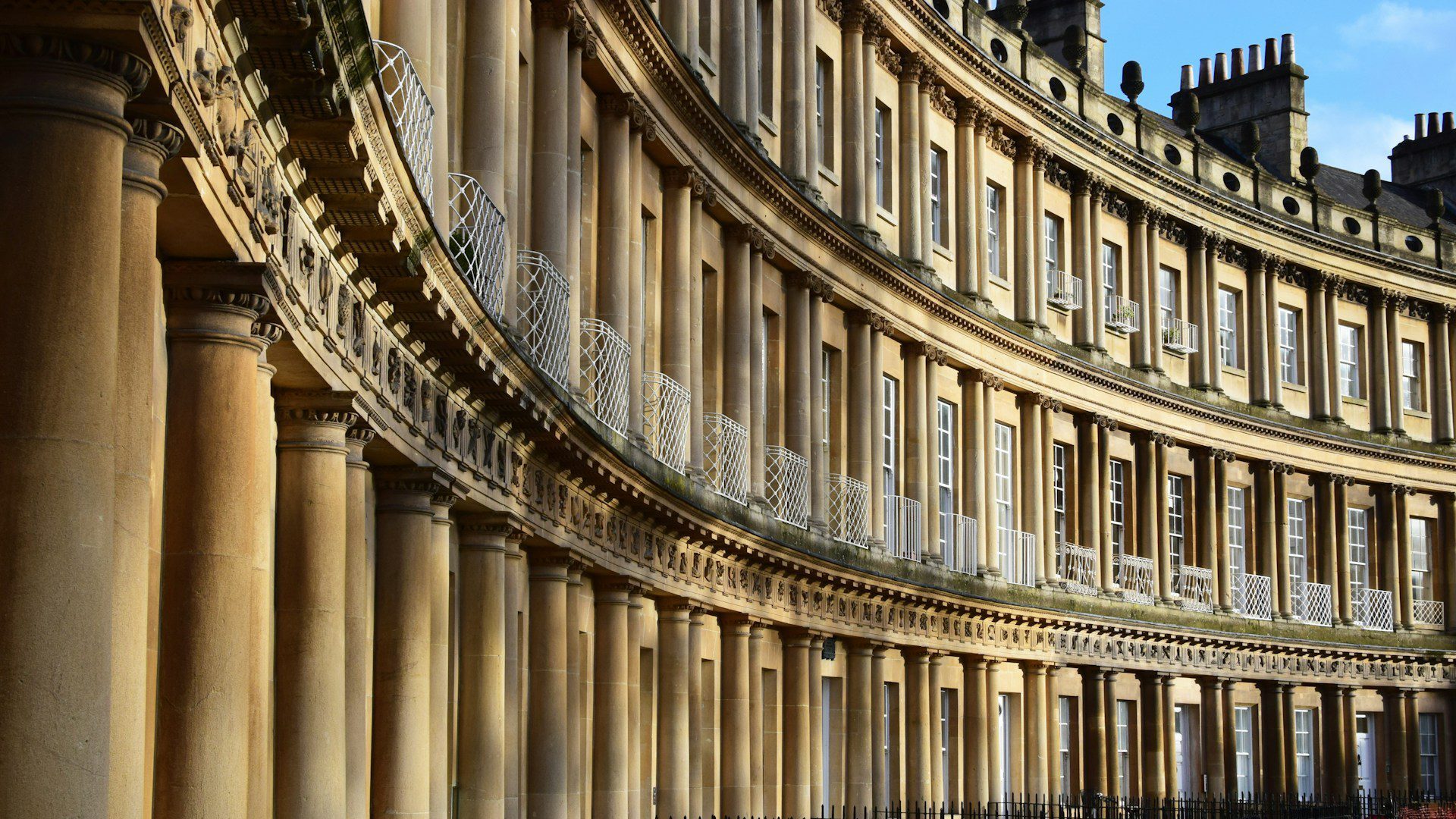exterior of the Royal Crescent in Bath, looking along the terraced houses from a close angle